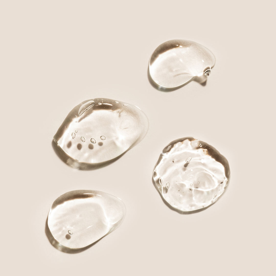 Een close-up van een druppel water op een wit oppervlak - Vitamine C Serum.