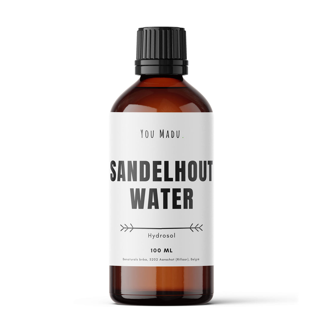 Een bruine fles met een wit label, gevuld met sandelhoutwater - een natuurlijke oplossing voor huidaandoeningen zoals acne en eczeem. Kan gebruikt worden als toner, reinigingsmiddel, en in aromatherapie voor kalmerende en ontspannende eigenschappen. Duurzaam verpakt in glas.