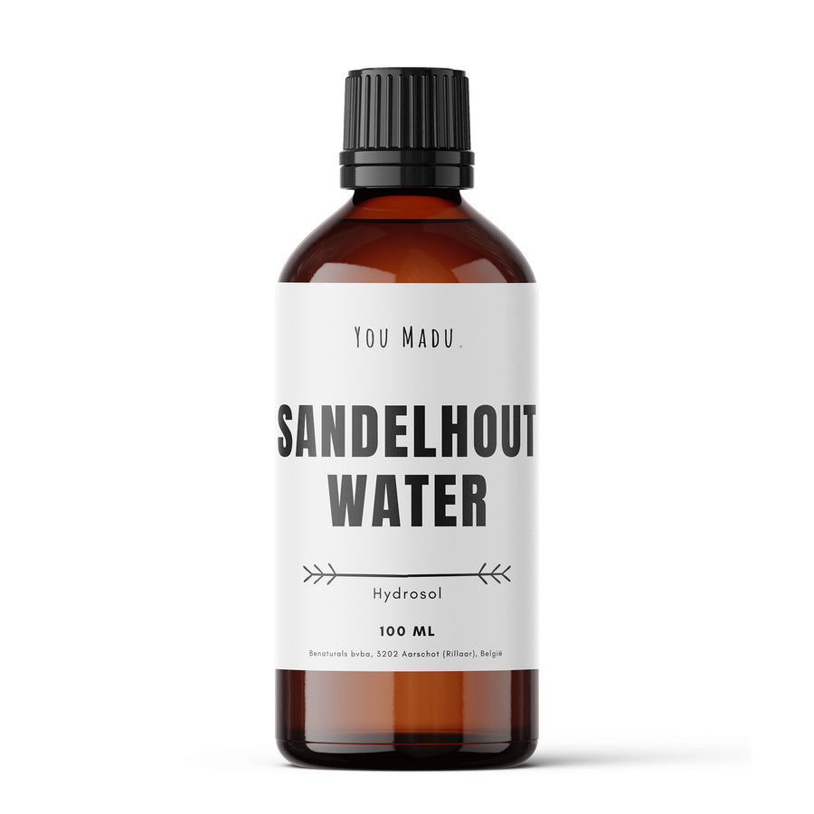 Een bruine fles met een wit label, gevuld met sandelhoutwater - een natuurlijke oplossing voor huidaandoeningen zoals acne en eczeem. Kan gebruikt worden als toner, reinigingsmiddel, en in aromatherapie voor kalmerende en ontspannende eigenschappen. Duurzaam verpakt in glas.