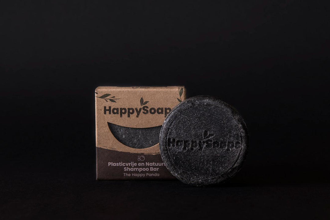 Een zwarte zeep bar naast een doos, Shampoo Bar - The Happy Panda