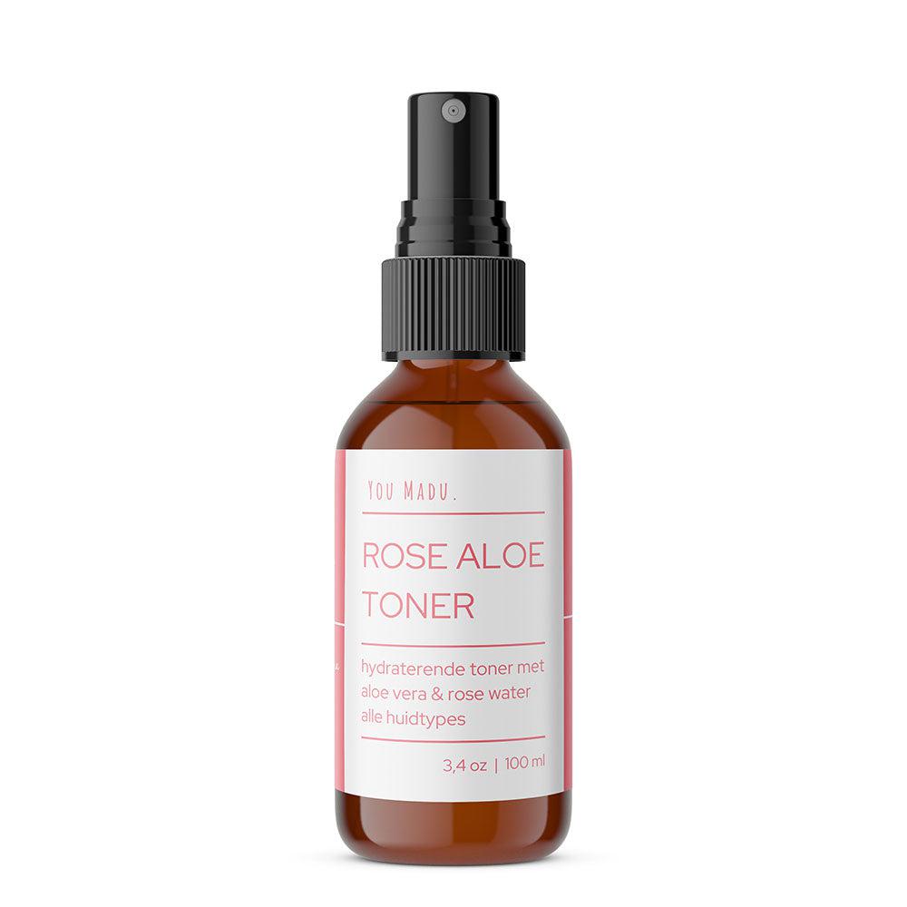 Een flesje Rose Aloe Toner met een verstuiver, een natuurlijke toner met aloë vera en rozenextract om overtollige oliën en onzuiverheden te verwijderen, de pH van de huid te reguleren en acne en puistjes te verminderen.